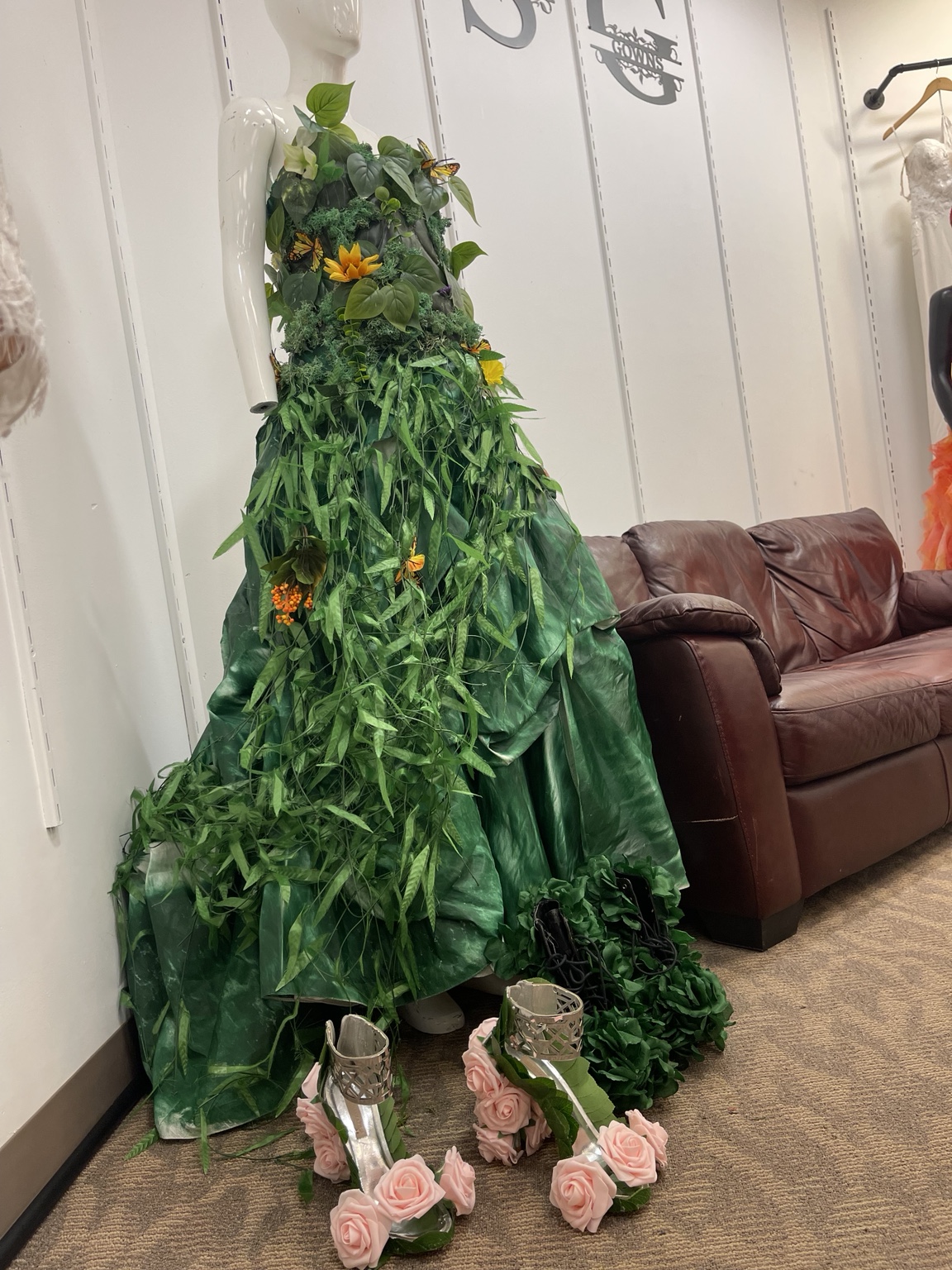 Botanical gown created from greenery on a mannequin, with floral couture shoes, displayed in the Runway Recycled boutique